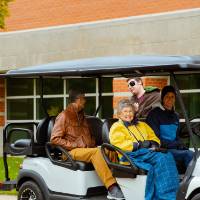 people smiling from golf cart